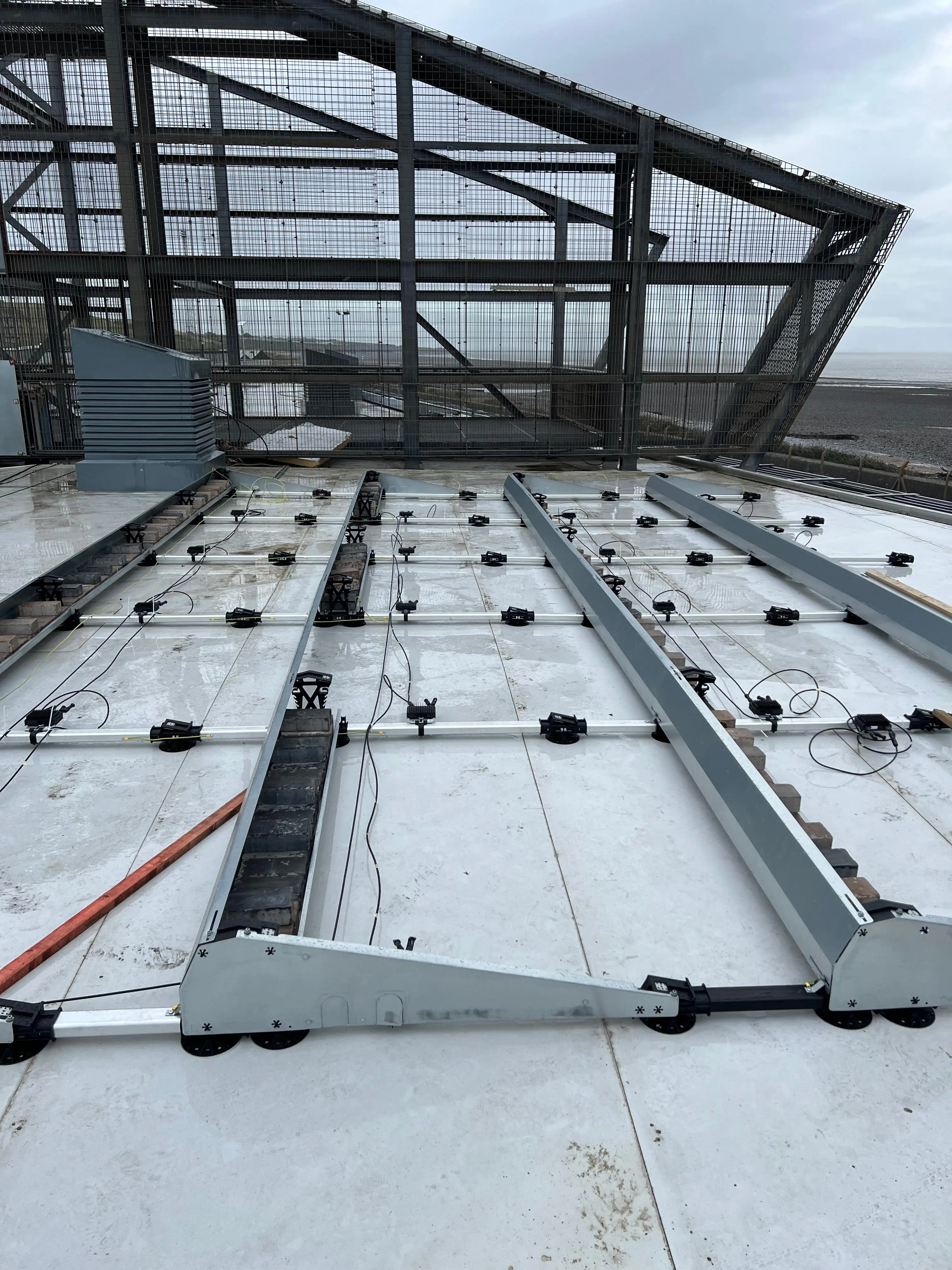 Mounting framework and DC cabling laid out on the flat roof at CCR Energy Aberthaw, ready for solar panels to be fitted.