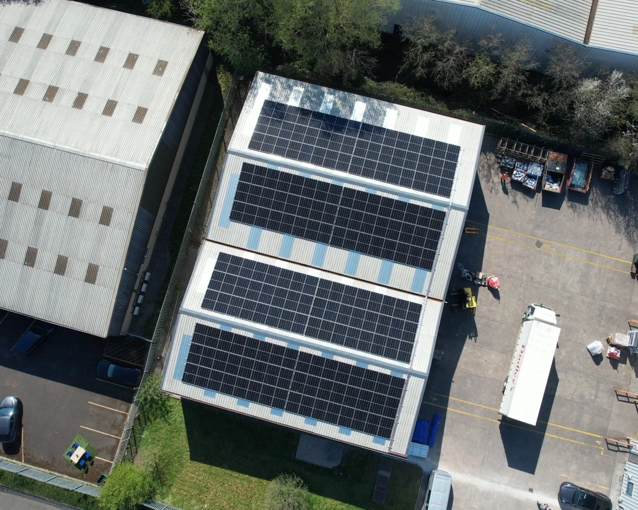 Top-down aerial view of the completed solar panel array on the roof of Dudley's Aluminium in Cardiff, showing the rows of panels laid out across the roof