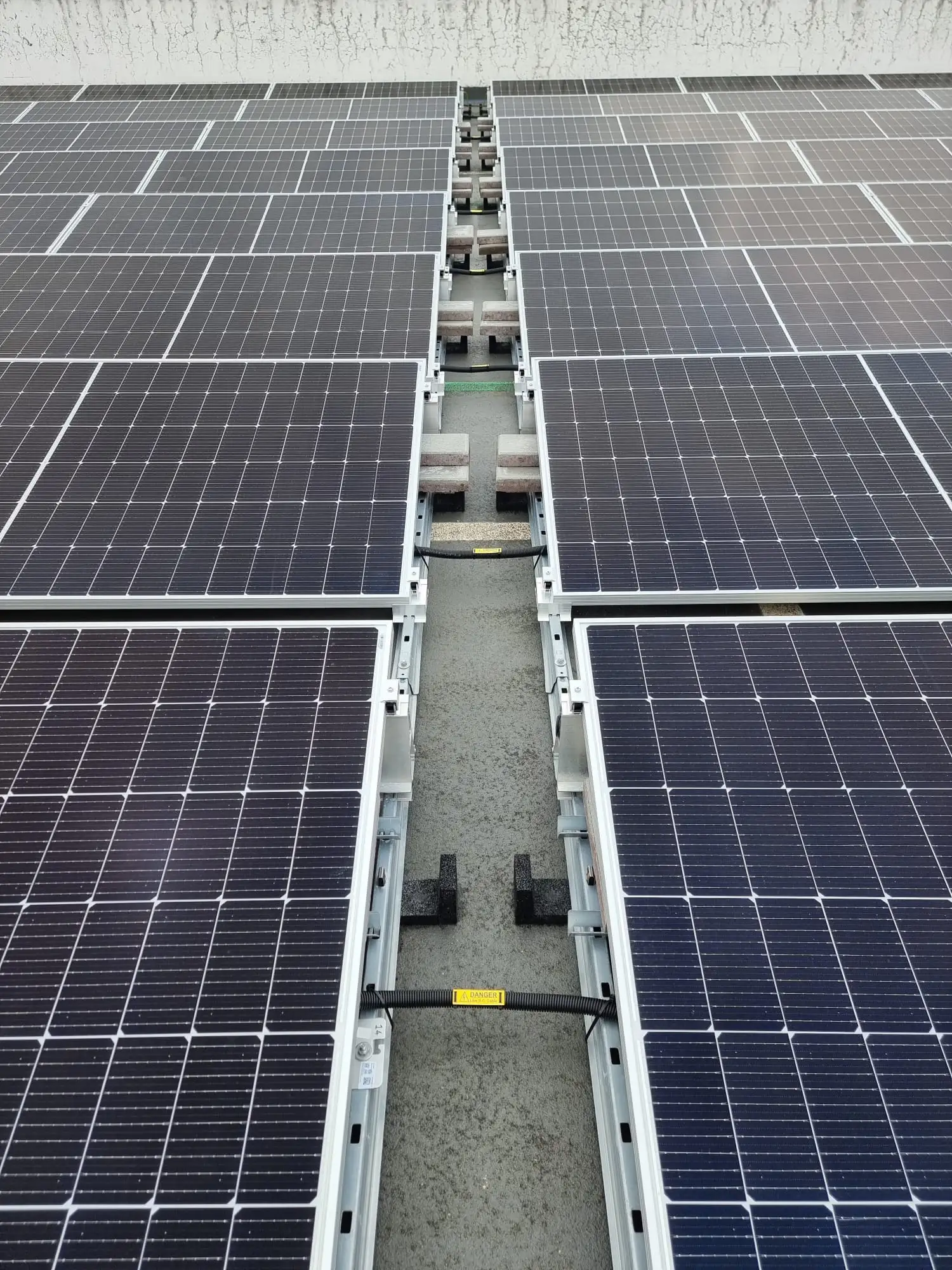 Close-up of solar panel rows with DC cabling routed neatly between them at the Kingsway Centre rooftop car park