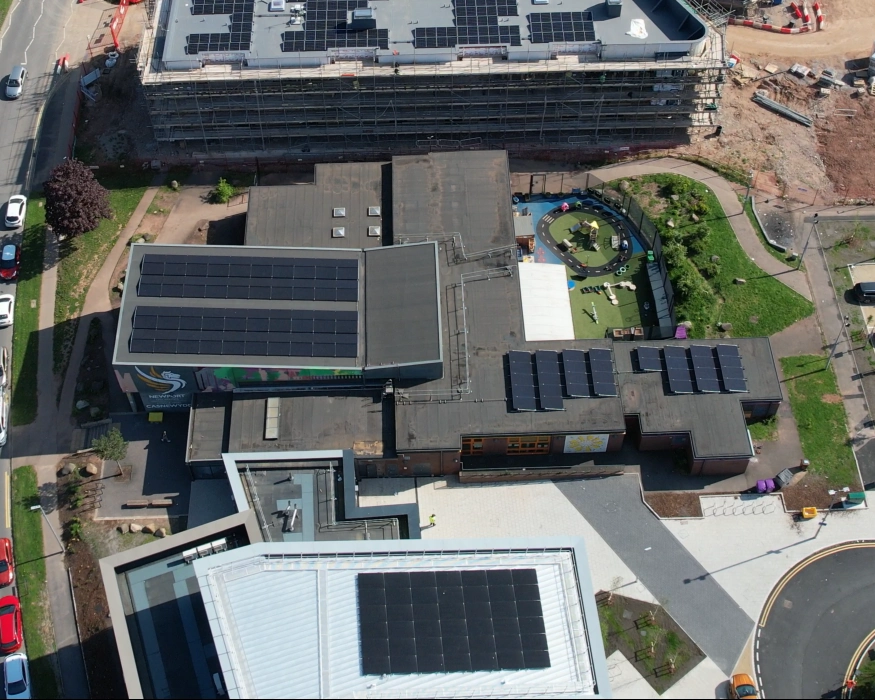 Aerial view of solar panel arrays spread across several rooftops at Ringland Community Centre in Newport.