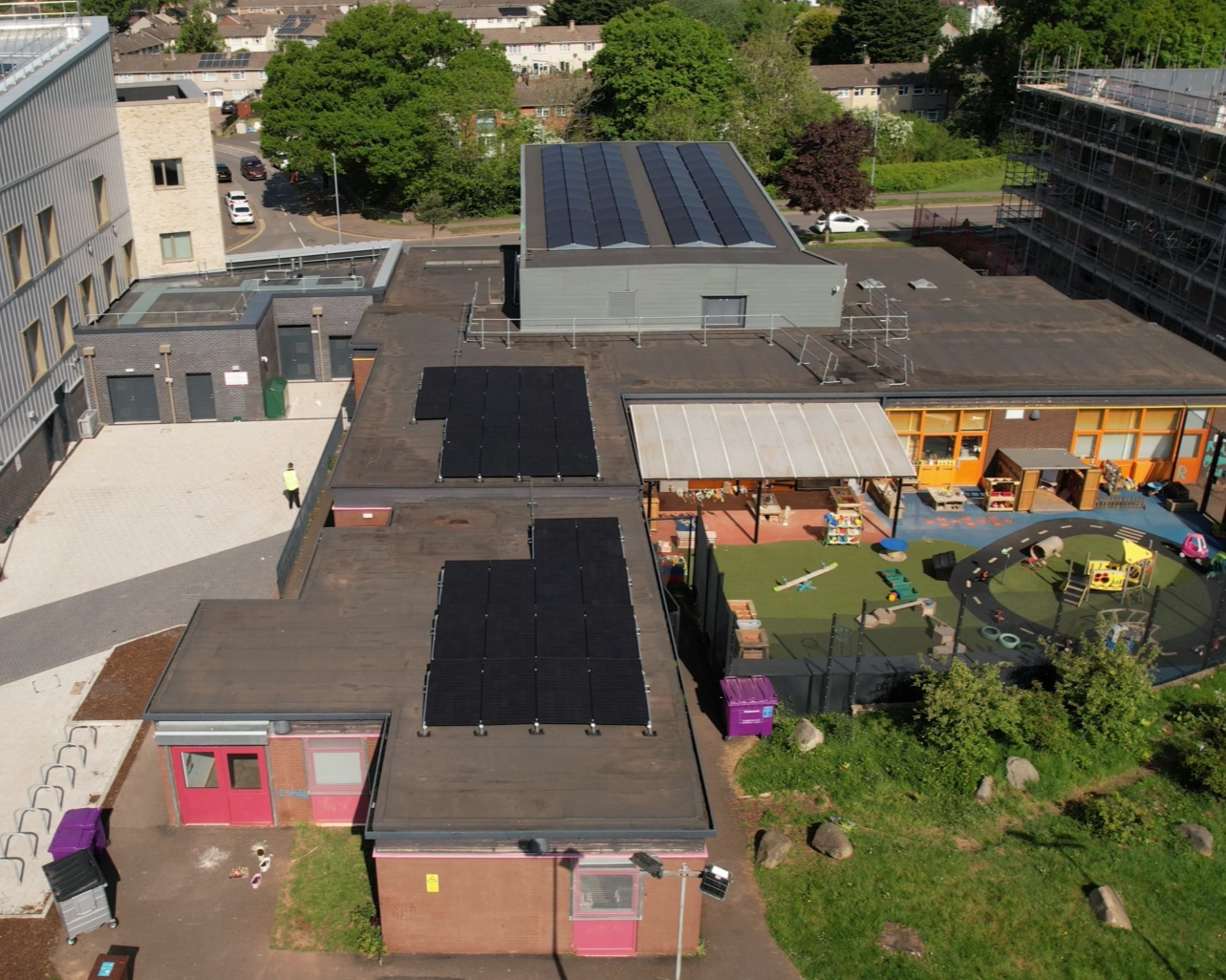 Solar panel arrays across several flat and pitched roofs at Ringland Community Centre in Newport.