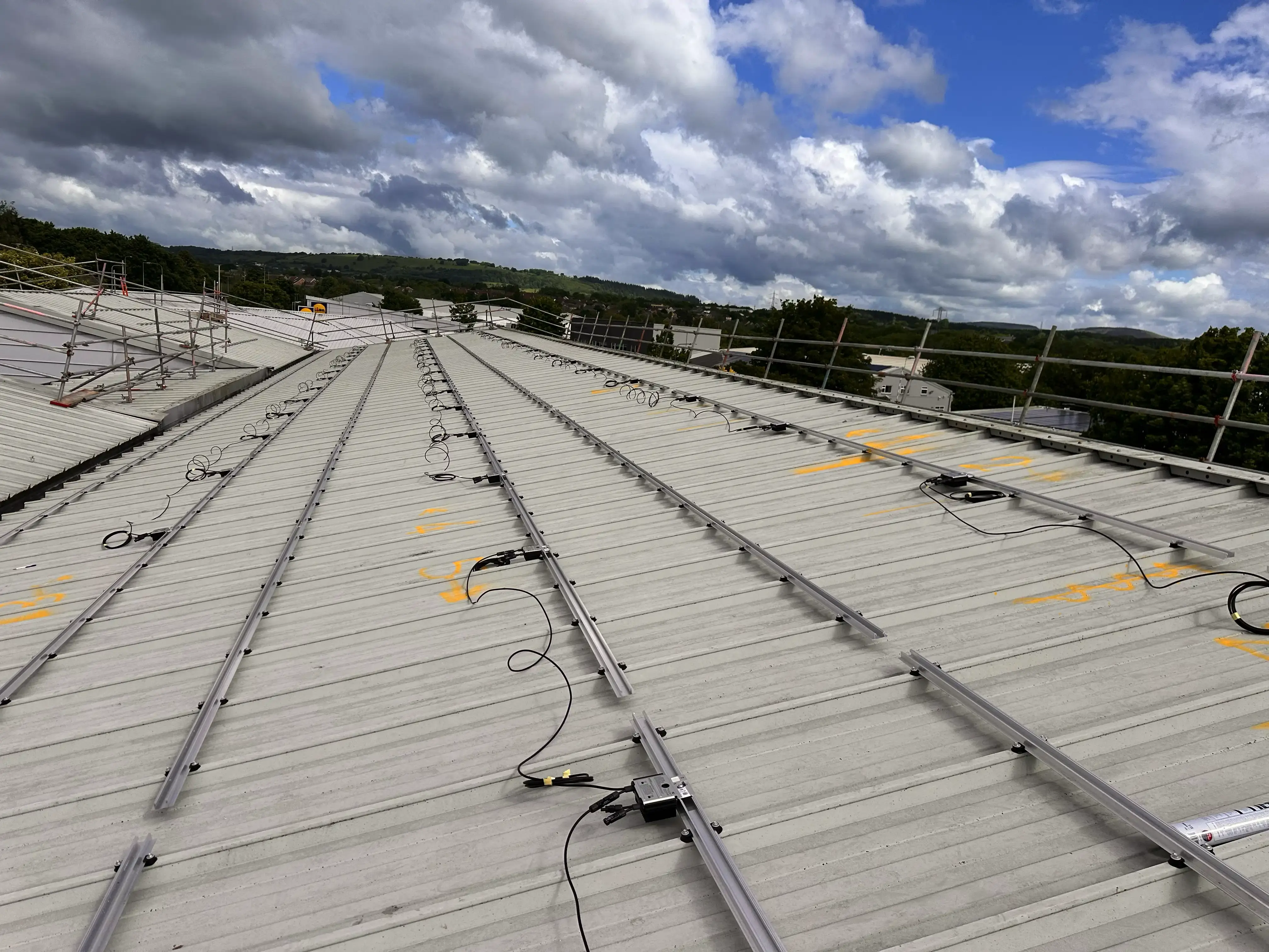 Solar PV optimisers and rail mounting on metal roof, Vision Court Cardiff.