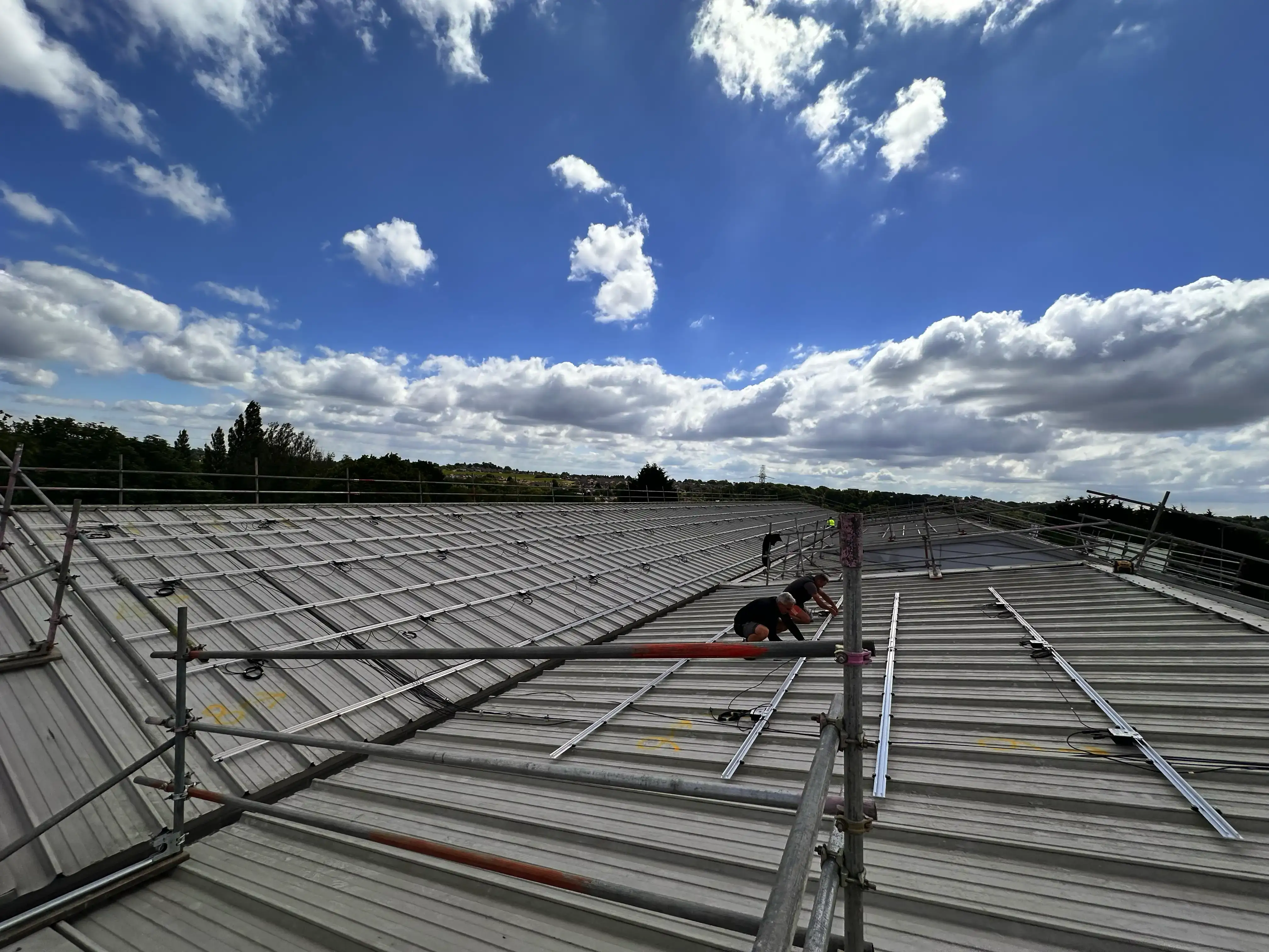 Engineers installing solar PV mounting rails, Vision Court Cardiff.