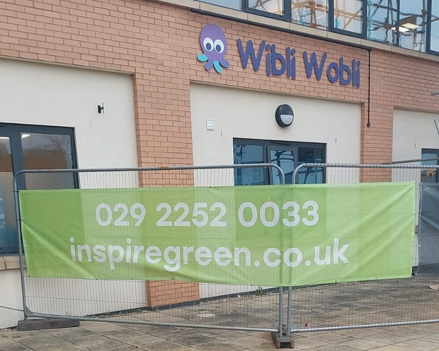 The Wibli Wobli Nursery building in Newport with an InspireGreen banner on the site fencing during the solar PV installation.