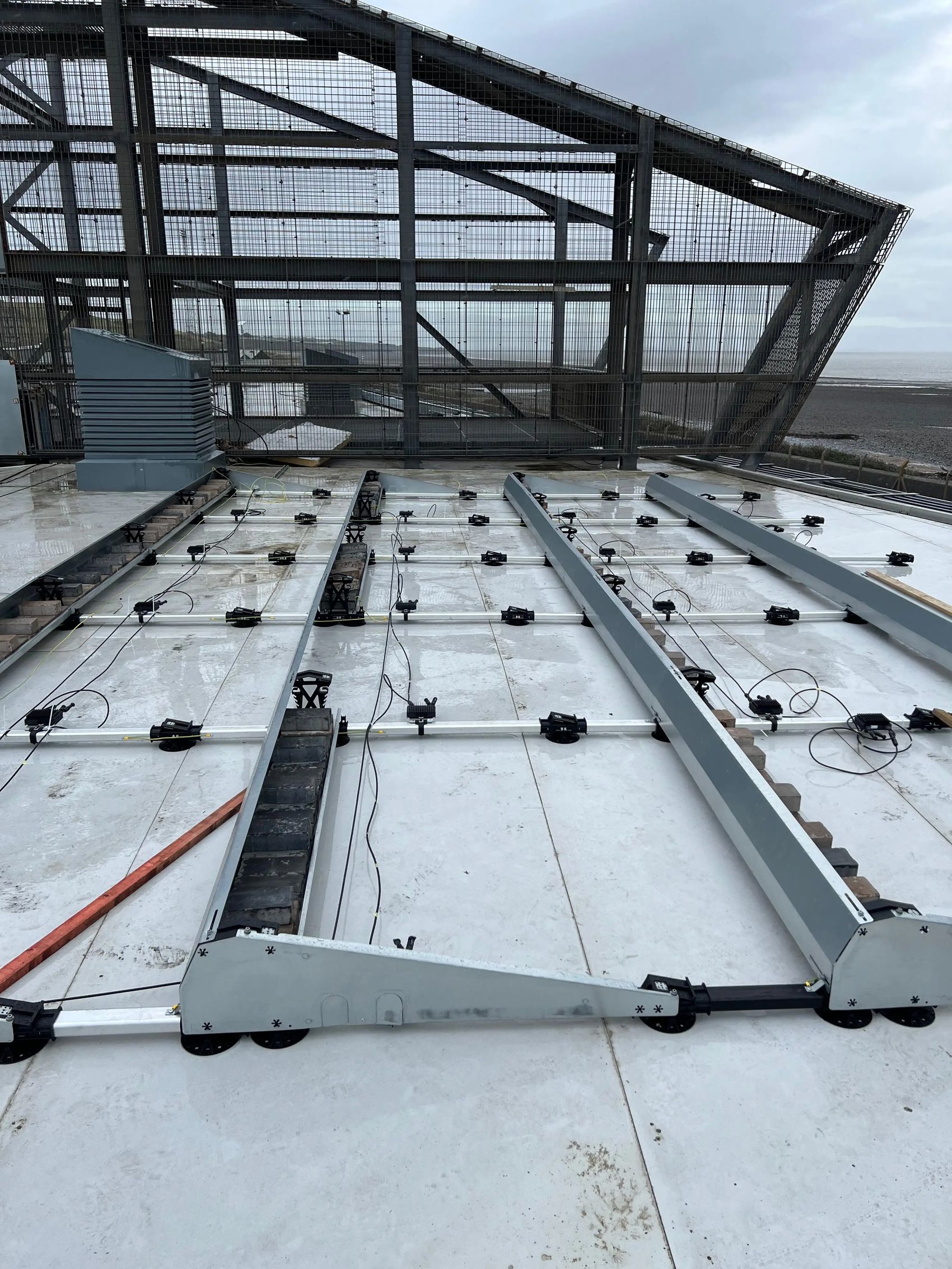 Mounting framework and DC cabling laid out on the flat roof at CCR Energy Aberthaw, ready for solar panels to be fitted.