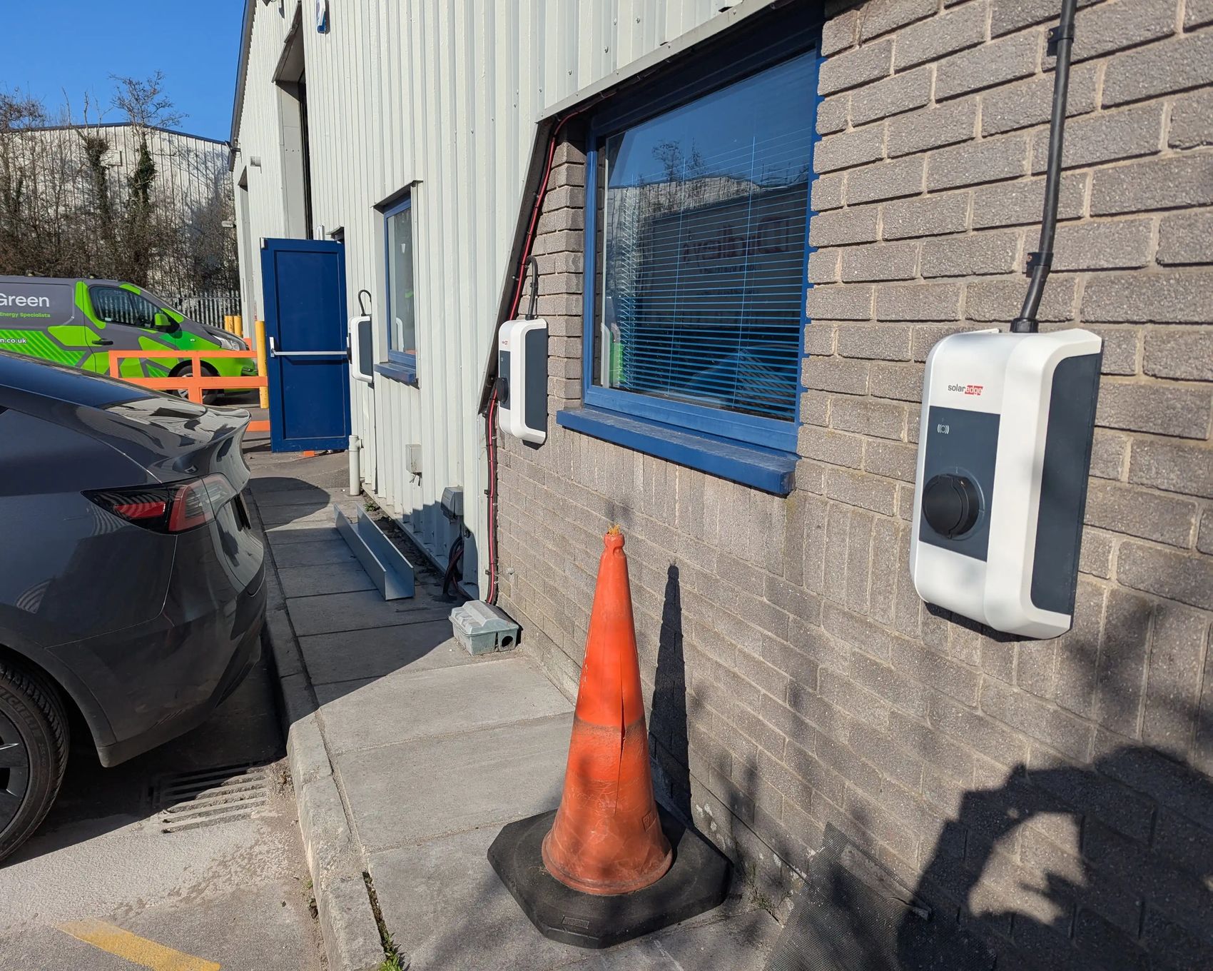 SolarEdge EV chargers installed on the wall at Dudley's Aluminium, Cardiff, with an InspireGreen van in the background
