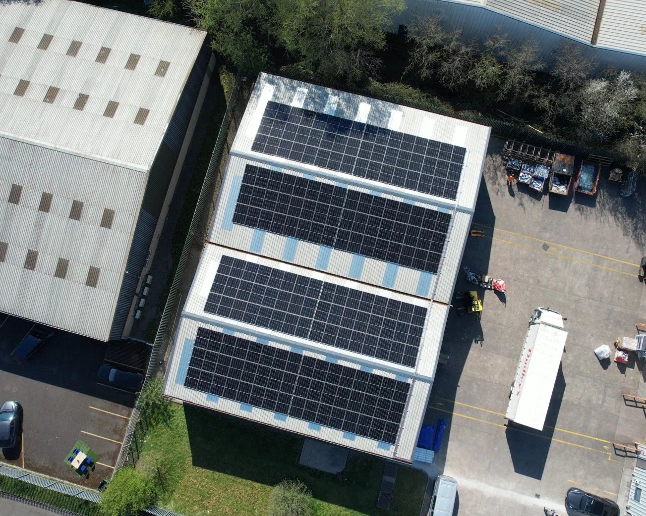 Top-down aerial view of the completed solar panel array on the roof of Dudley's Aluminium in Cardiff, showing the rows of panels laid out across the roof