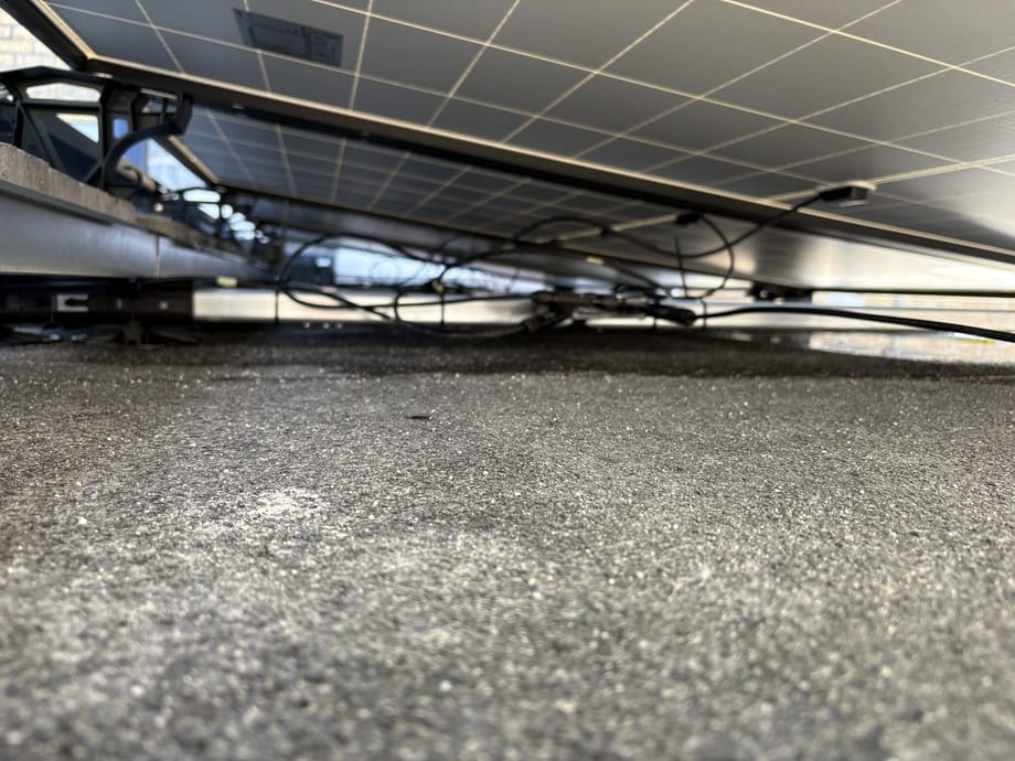 DC cabling and mounting frame beneath the rooftop solar array at Trailfinders in Cardiff