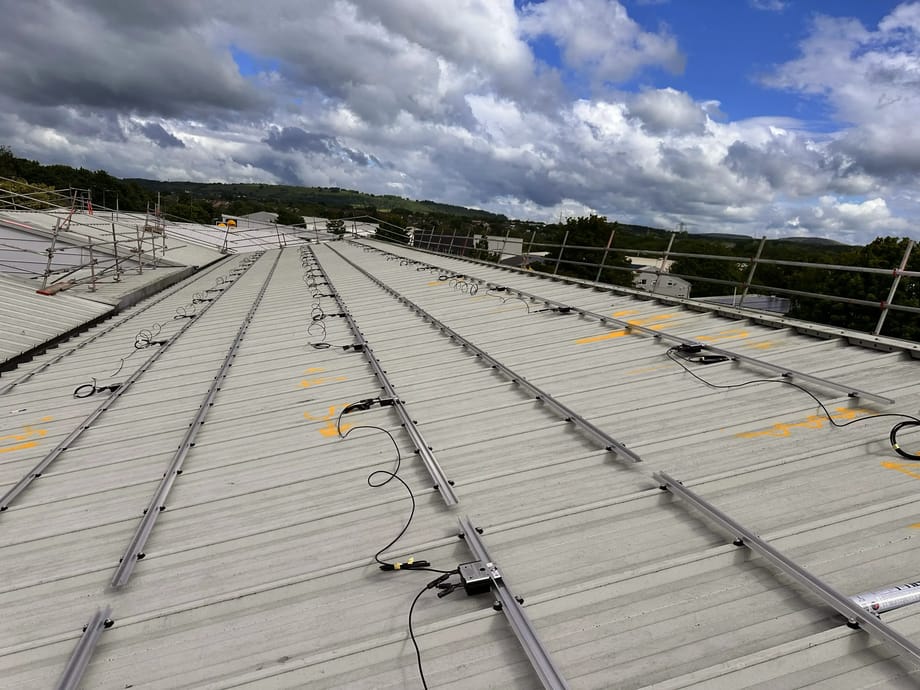 Solar PV optimisers and rail mounting on metal roof, Vision Court Cardiff.