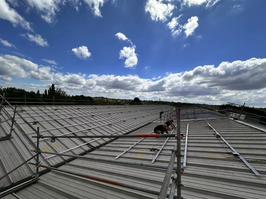 Engineers installing solar PV mounting rails, Vision Court Cardiff.