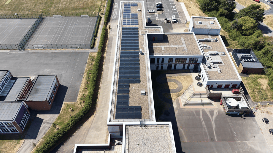 Rooftop solar panels along the main block at Ysgol Gyfun Gwent Is Coed, a secondary school in Newport, seen from an angled aerial view